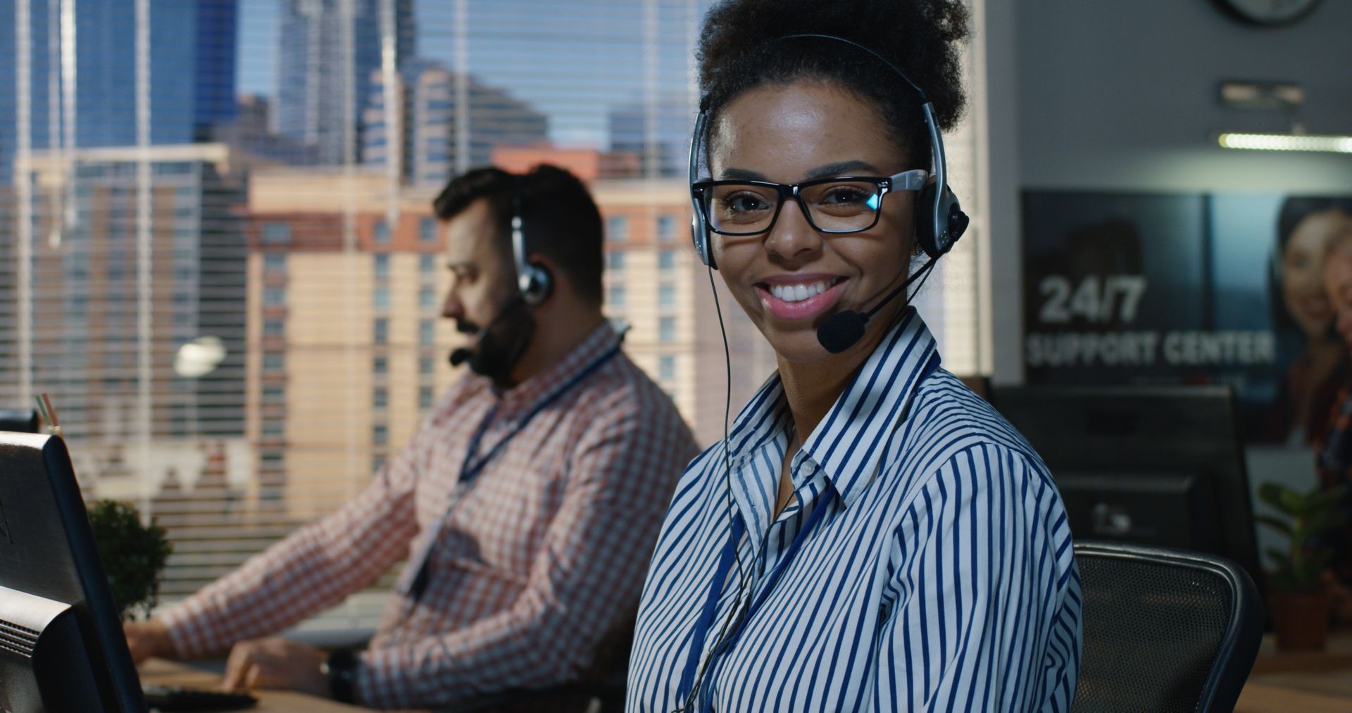 Medium shot of woman working at his desk in a support center